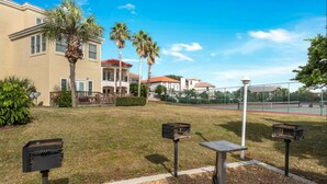 A residential area with a tennis court, a mailbox, and a building with a red roof. - OCEAN PEARL 2-bedroom condo in peaceful Destin  (Destin)