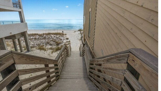 A wooden staircase leading to a beach with a clear view of the ocean. - OCEAN PEARL 2-bedroom condo in peaceful Destin  (Destin)