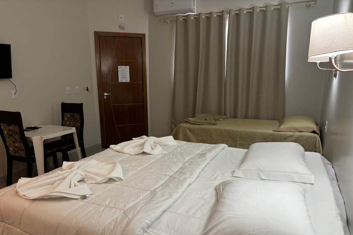 A hotel room with a bed, a desk, and a chair.