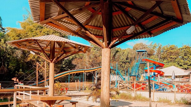 Een houten terras met picknicktafels en een overdekte paviljoen.