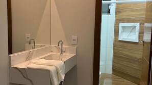 Een moderne badkamer met een grote spiegel, twee wasbakken en een houten wastafelmeubel.