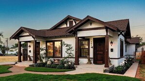 A two-story house with a gabled roof, a front porch, and a well-maintained lawn. - Royal Estate Maison Entiere de Luxe (Abilene)