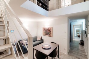 Un interior moderno con una escalera, un comedor y una sala de estar.