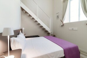 A bedroom with a bed, a nightstand, a lamp, a window with curtains, and a staircase. - Diaz 8 - MyHomeinComo (Como)