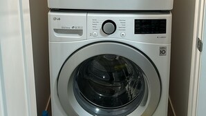 A stacked washer and dryer unit with a control panel displaying various settings. - Cozy and Private Suite - Free On-Prem Parking & PS5 Available (Calgary)