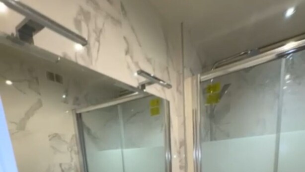 Une salle de bain moderne avec deux lavabos, un grand miroir et une douche à l’italienne.
