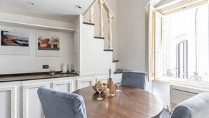 A dining area with a round table, chairs, a bottle, and glasses. - GuestHost - House Overlooking the Harbour (Trani)