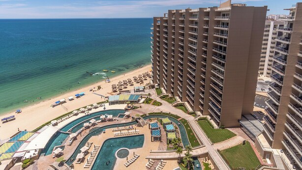A high-rise hotel with a pool area, beach access, and ocean views. - Las Palomas Phase II Cabrillo 1506 Exceptional Oceanview 2BR 2BA Unit (Puerto Peñasco)