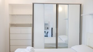 Une chambre d’hôtel avec un lit, une armoire et un miroir.