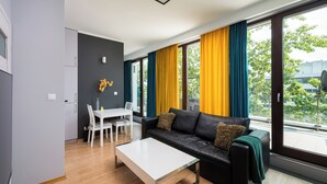 A modern living room with a sofa, coffee table, and dining area.
