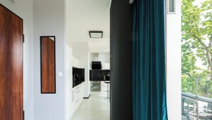 A modern kitchen with white cabinets, a black countertop, and a stainless steel oven.