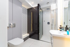 A modern bathroom with a toilet, a shower, and a sink. - Rynek Wrocław Deluxe Studio (Wrocław)