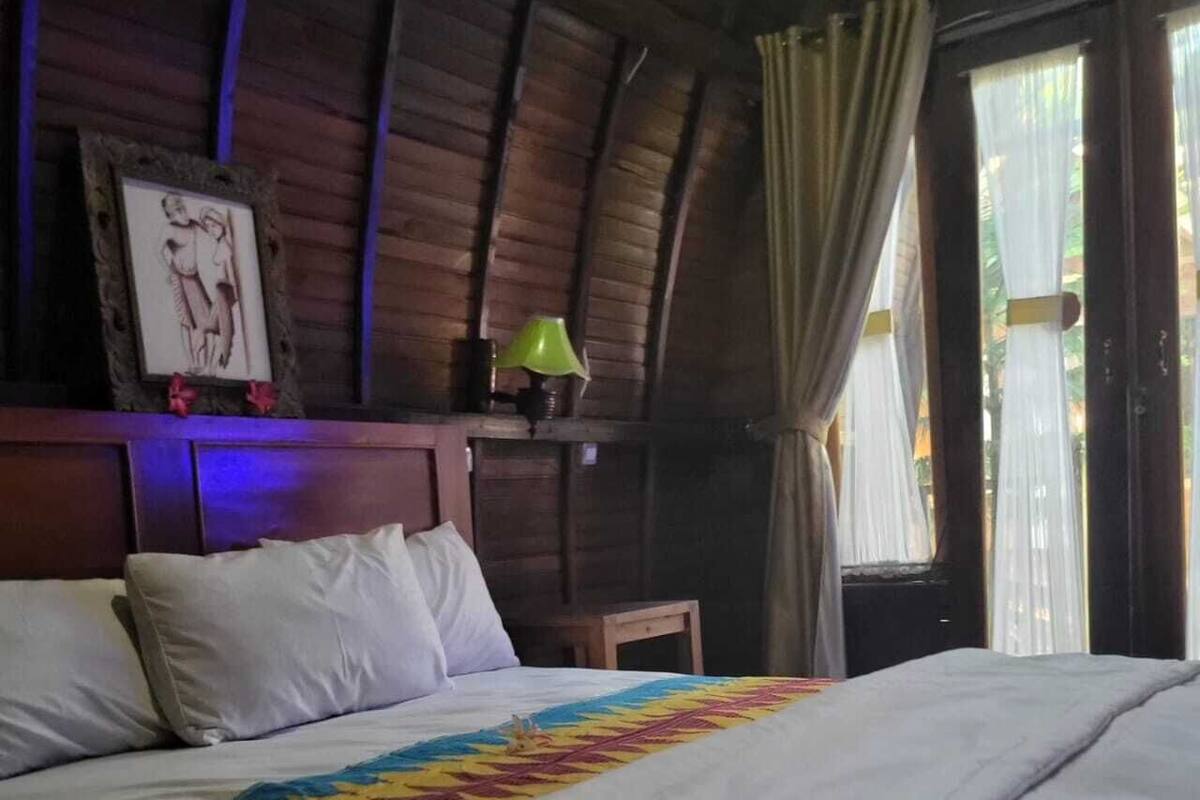 Un lit avec du linge de lit blanc et une couverture aux motifs géométriques colorés.