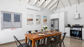 A modern kitchen with white cabinets, a stainless steel refrigerator, and a built-in oven.