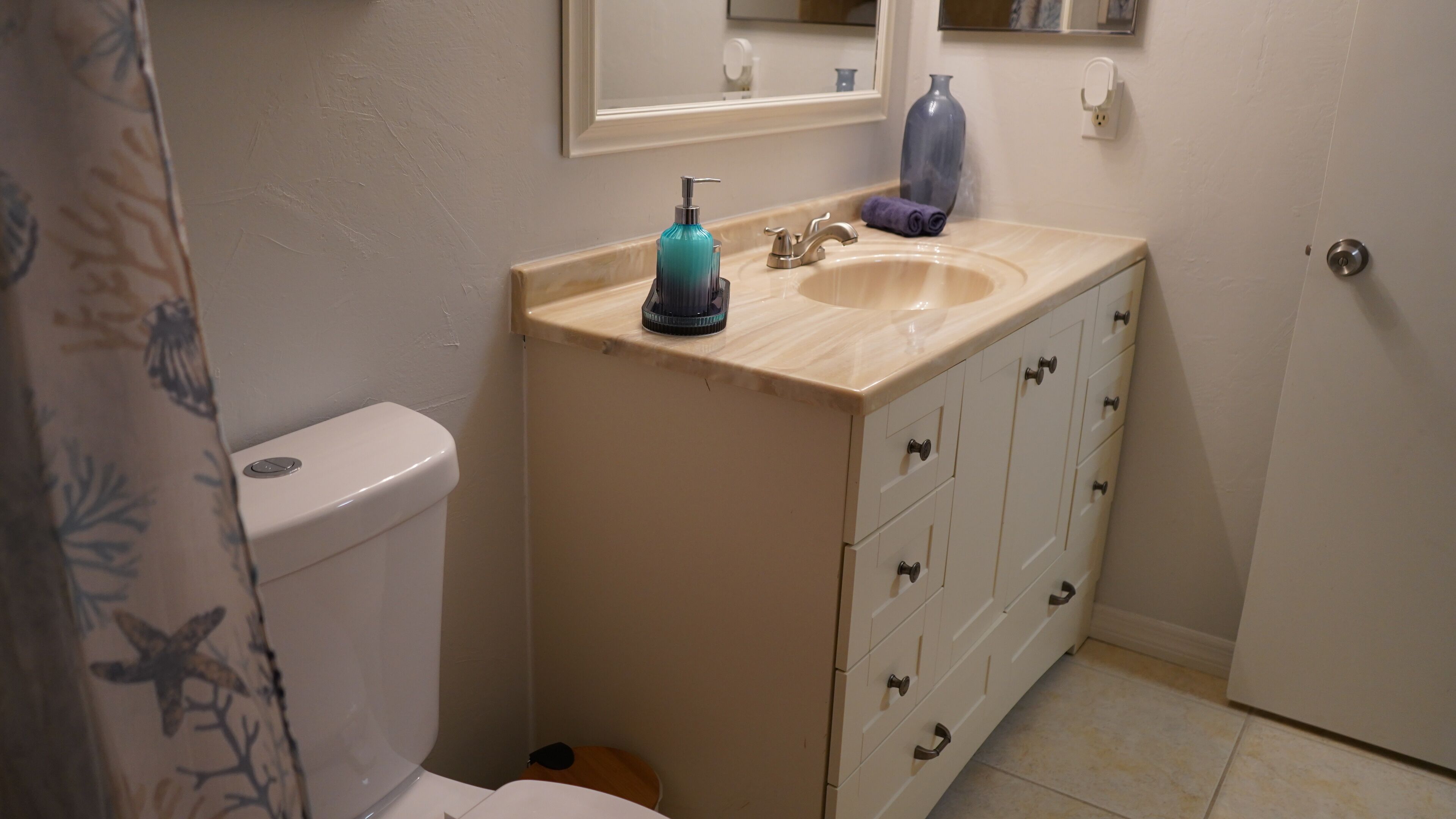 Une salle de bain avec des toilettes, un lavabo et des placards.