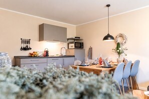 A modern kitchen with a dining area, equipped with a microwave, stove, and various utensils. - Vacation apartment MaNiTo with 2 bedrooms, max. 6 persons - Smart Resorts Haus (Winterberg)