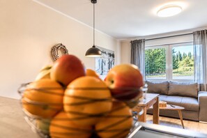 Una sala de estar con un sofá, una mesita y un frutero sobre una mesa.