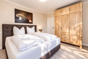 A hotel room with a large bed, a wardrobe, and a painting on the wall. - Vacation apartment MaNiTo with 2 bedrooms, max. 6 persons - Smart Resorts Haus (Winterberg)