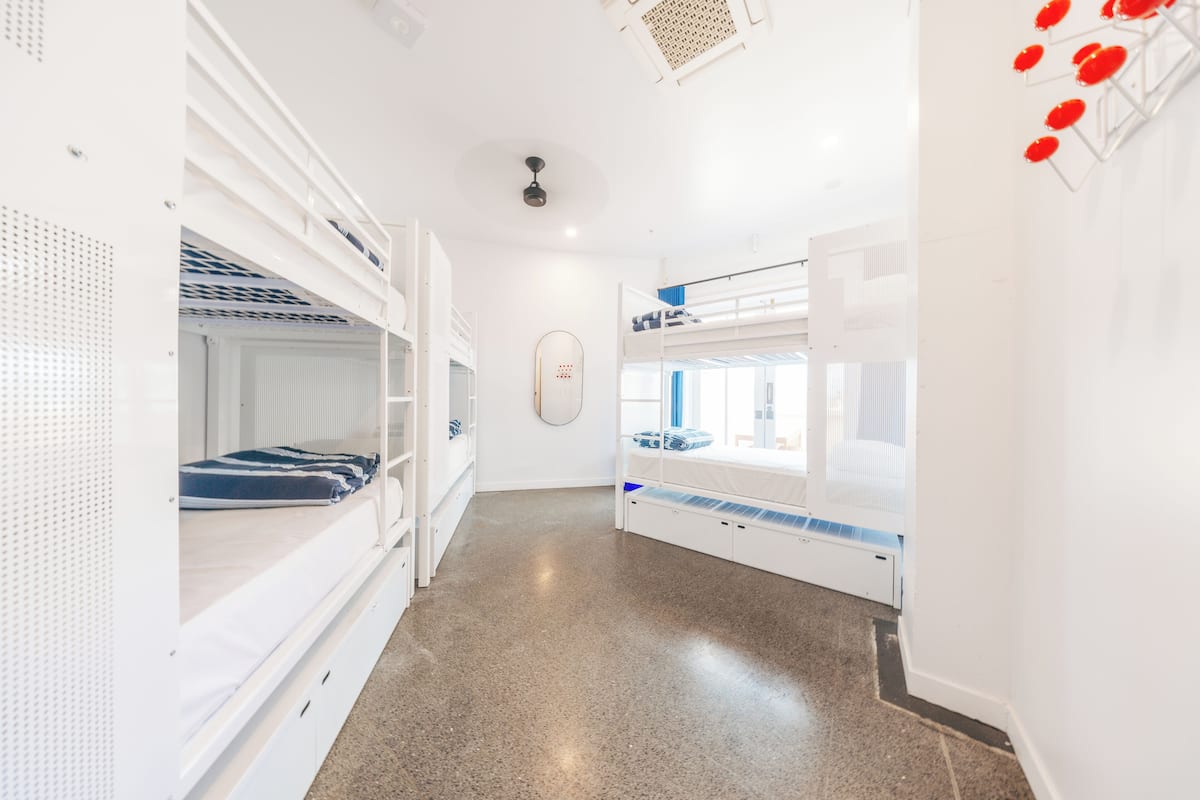 A clean, modern hotel room with bunk beds and a kitchenette.