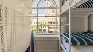 Dormitori amb lliteres i una gran finestra apuntada que donava a una vista panoràmica de la ciutat.