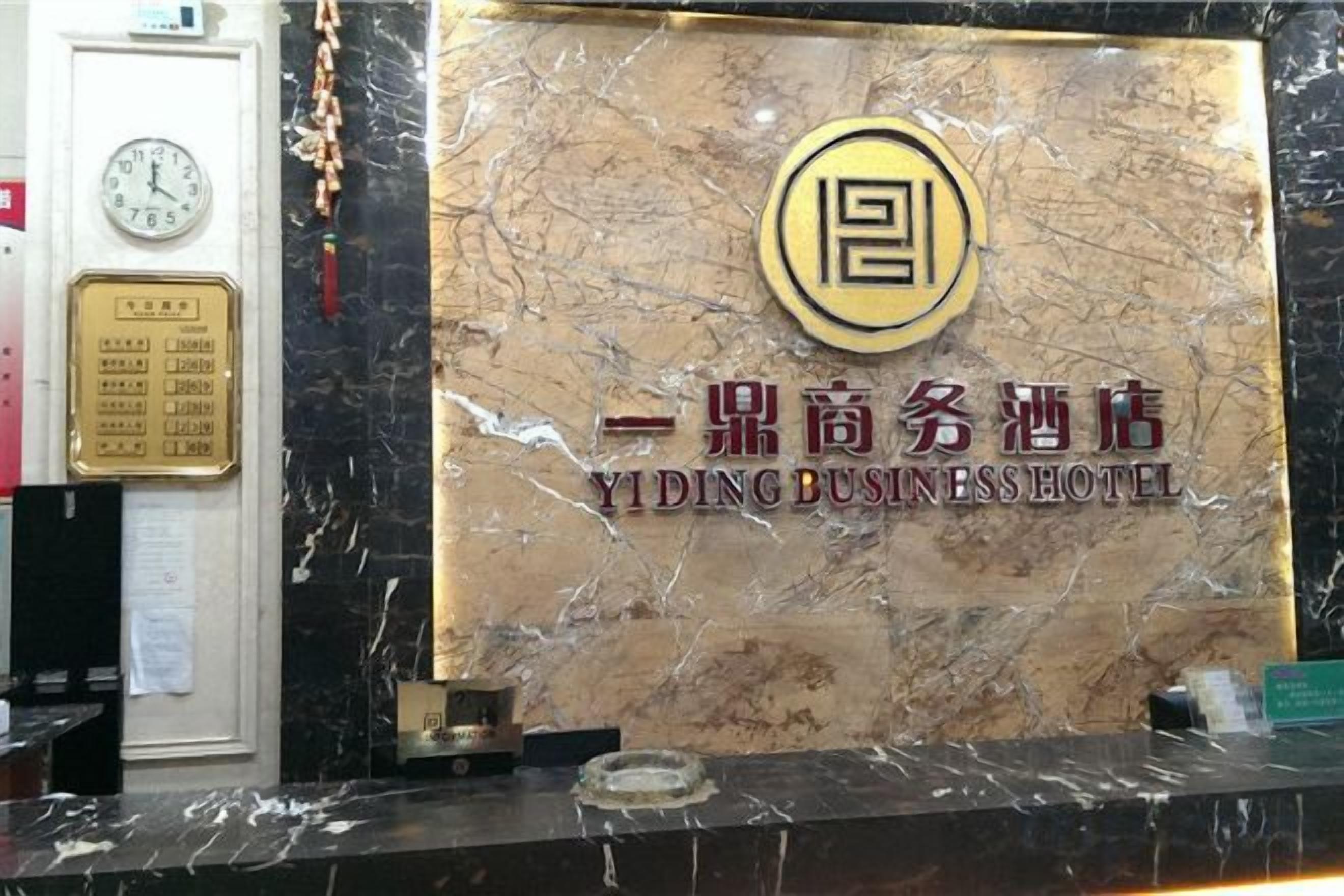 A reception desk with a marble top, a clock, and a plaque.