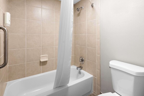 A bathroom with a bathtub, a showerhead, and a toilet. - Quality Inn Nashville - Opryland Area (Nashville)
