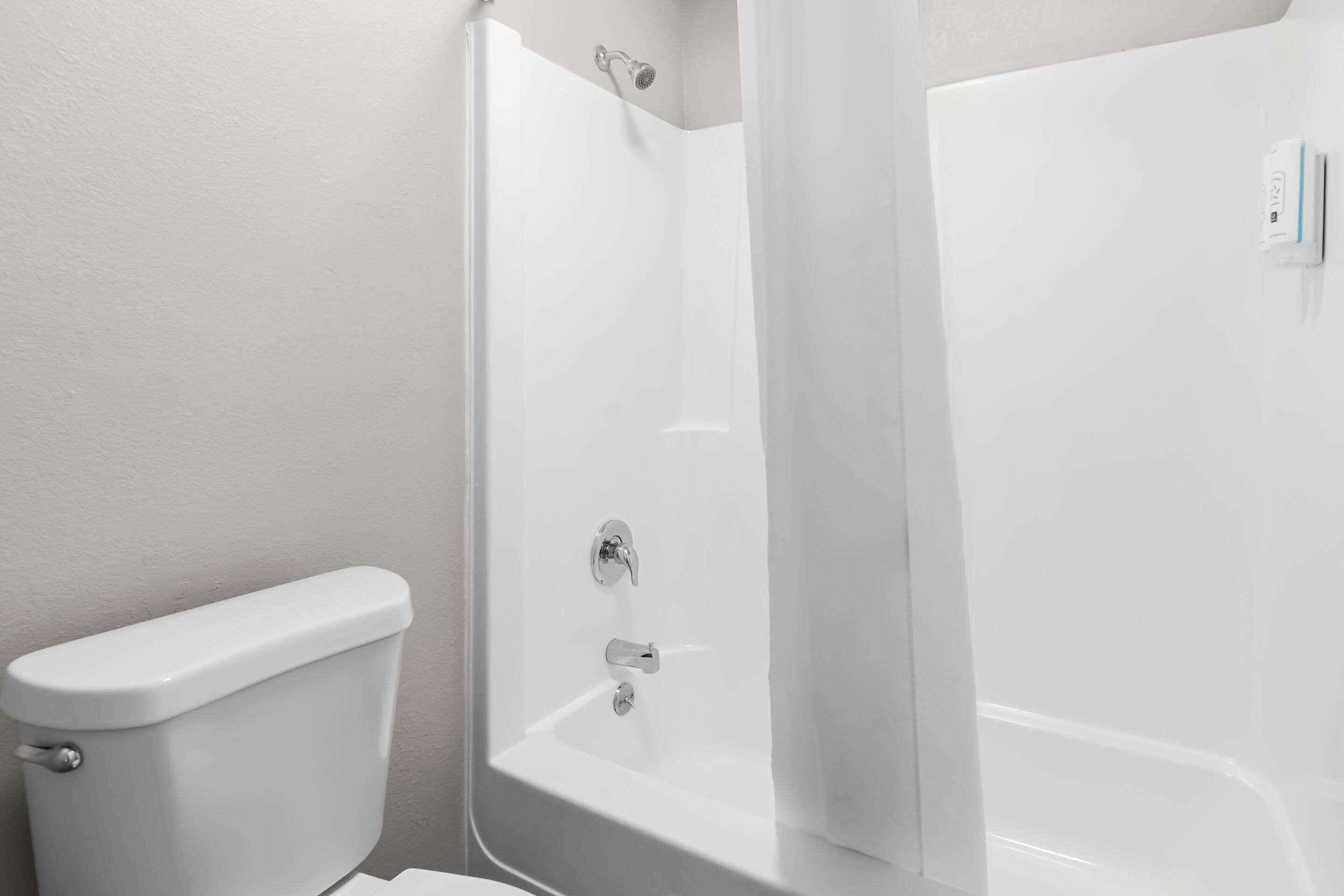 A bathroom with a toilet, a shower, and a bathtub.