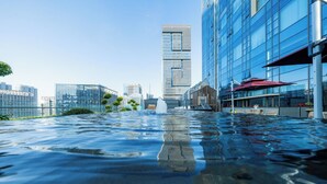 A rooftop pool with a cityscape view, including modern buildings and a fountain. - YTL ChangChengYunYue Hotel (Wenzhou)