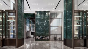 A modern lobby with marble walls, glass display cases, and a seating area. - YTL ChangChengYunYue Hotel (Wenzhou)