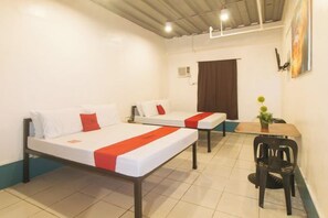 A hotel room with two beds, a dining table, and a chair. - RedDoorz @ Crowne One Condo (Quezon City)