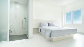 A modern bedroom with a bed, a shower, and a large window. - The Axara Bali (Jimbaran)