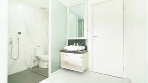 Deluxe appartement, kitchenette | Badkamer | Een douche, handdoeken, zeep, shampoo