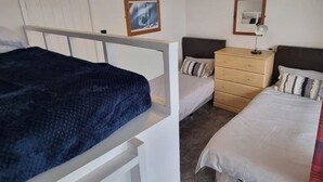 Ein Zimmer mit zwei Betten, einem Schminktisch und einem Spiegel.