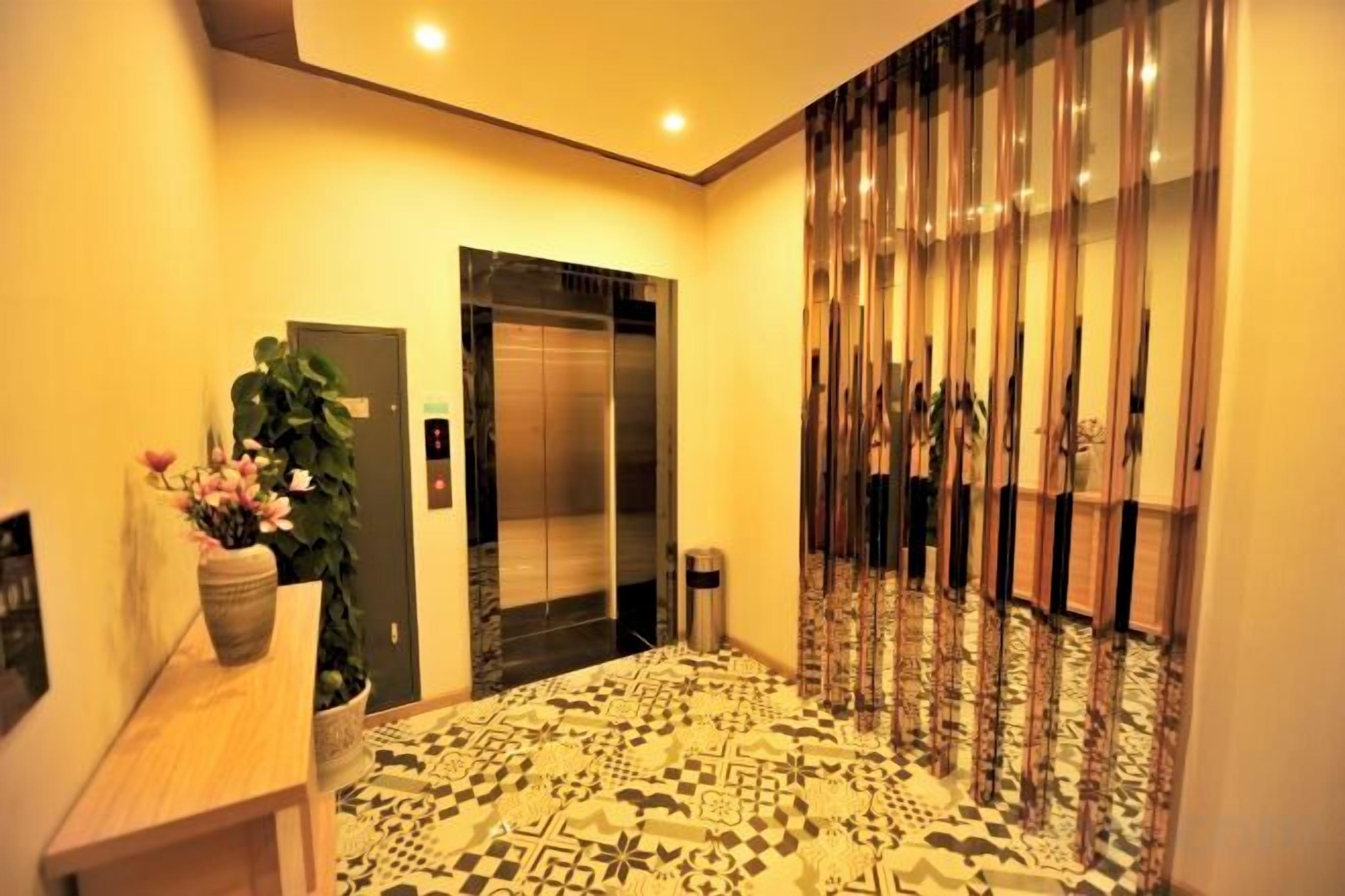 An elevator with a modern design, a patterned floor, and a potted plant on a table.