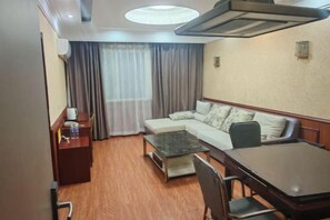 Relax in this stylish room with a sofa, desk, and dining table, offering ample space to work and unwind.