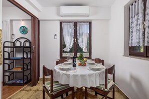 A dining area with a round table set for four, surrounded by chairs. - House Rose With Private Pool And Garden, Pinezići, Croatia (Pinezići)