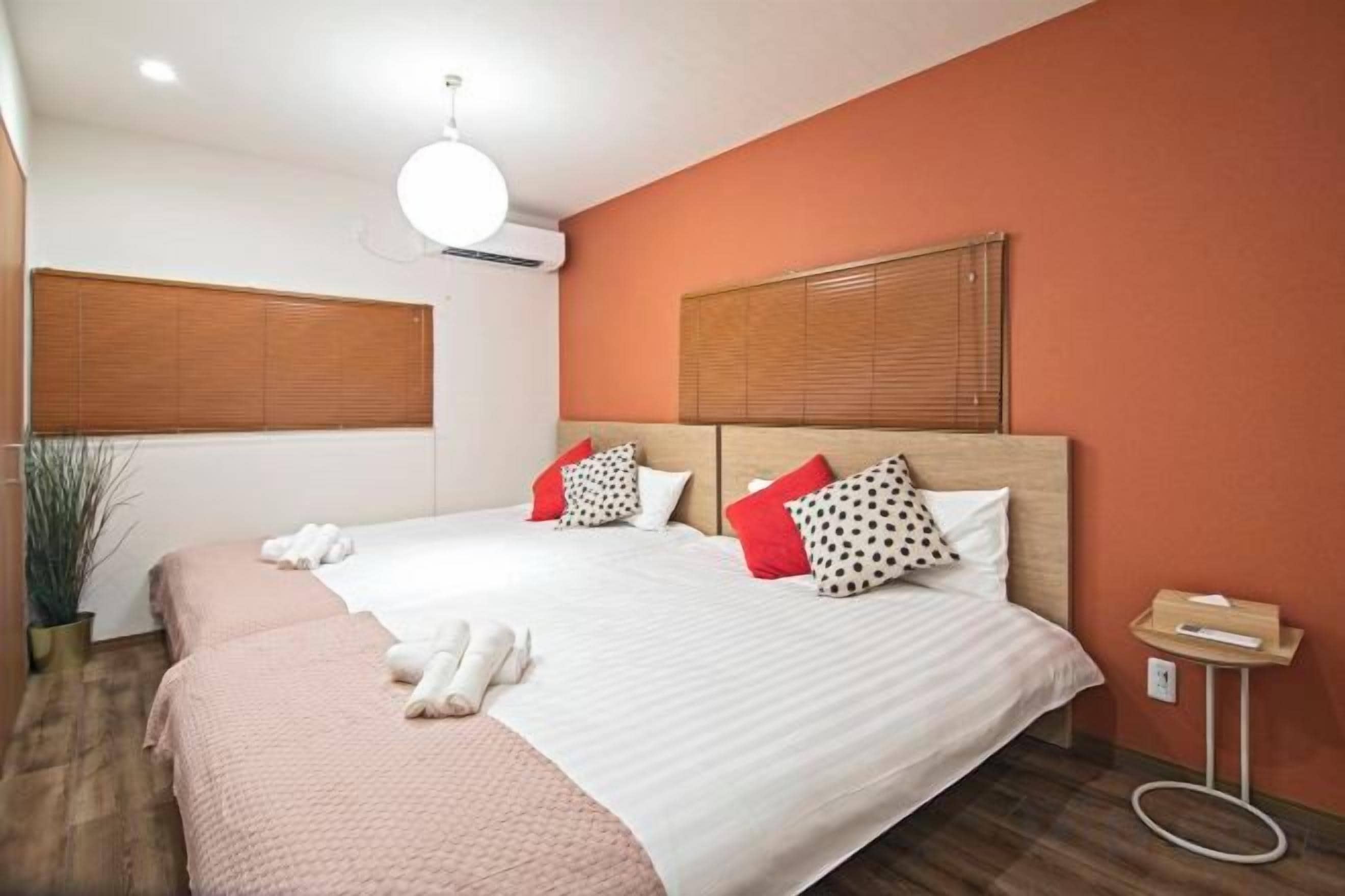 A hotel room with a large bed, two bedside tables, a bedside lamp, and a potted plant.