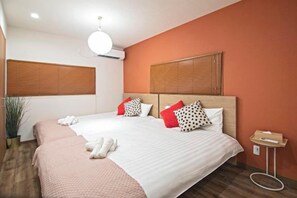 Une chambre d’hôtel avec un grand lit, deux tables de chevet, une lampe de chevet et une plante en pot.