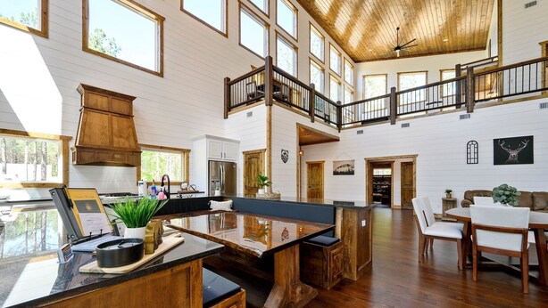 A spacious kitchen with a central island, wooden cabinets, and a view of the outdoors.