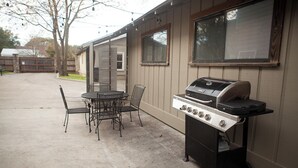 Une terrasse extérieure avec un barbecue et des chaises en métal.
