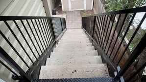 Un escalier avec des rampes en métal menant à une porte.
