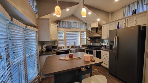 A kitchen with a central island, a refrigerator, and a stove. - Luxurious quiet cottage on 25 acre rescue farm. In the forest above Port Angeles (Port Angeles)
