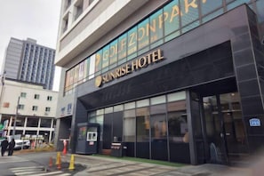 A modern building with a sign for Sunrise Hotel.