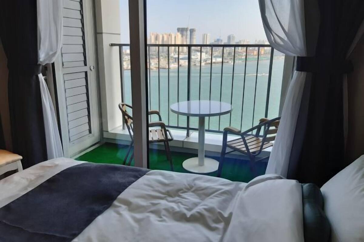 A hotel room with a balcony, a round table, and chairs.