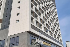 A high-rise building with a sign indicating 'GRAND OPEN'.