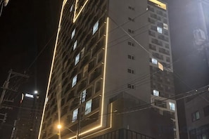 A multi-story building with illuminated windows and a visible power line structure. - SamsungHome2 - 1F Junior Suite 1.5Room, Ocean & Lake View, Netflix Oe (Sokcho-si)