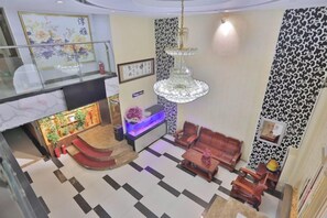 A hotel lobby with a reception desk, seating area, staircase, and a chandelier. - Tanya Hotel (Changchun Guoshang Department Store Tiandi 12th Fang) (Changchun)