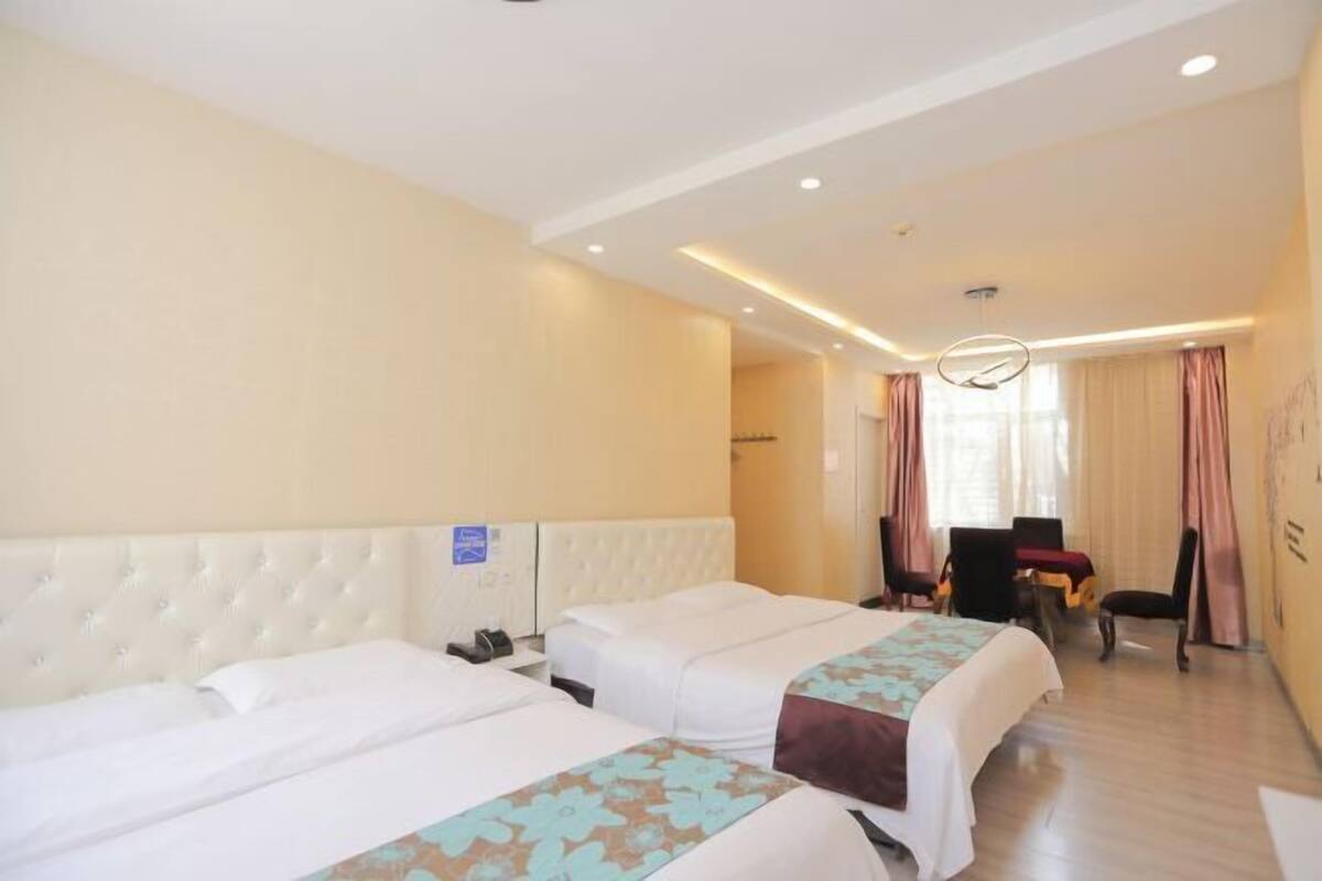 Une chambre d’hôtel avec deux lits, un bureau et une chaise.