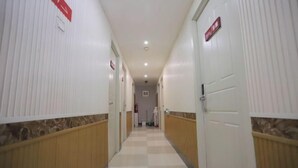 A hotel corridor with checkered flooring, white walls, and doors on both sides. - Tanya Hotel (Changchun Guoshang Department Store Tiandi 12th Fang) (Changchun)