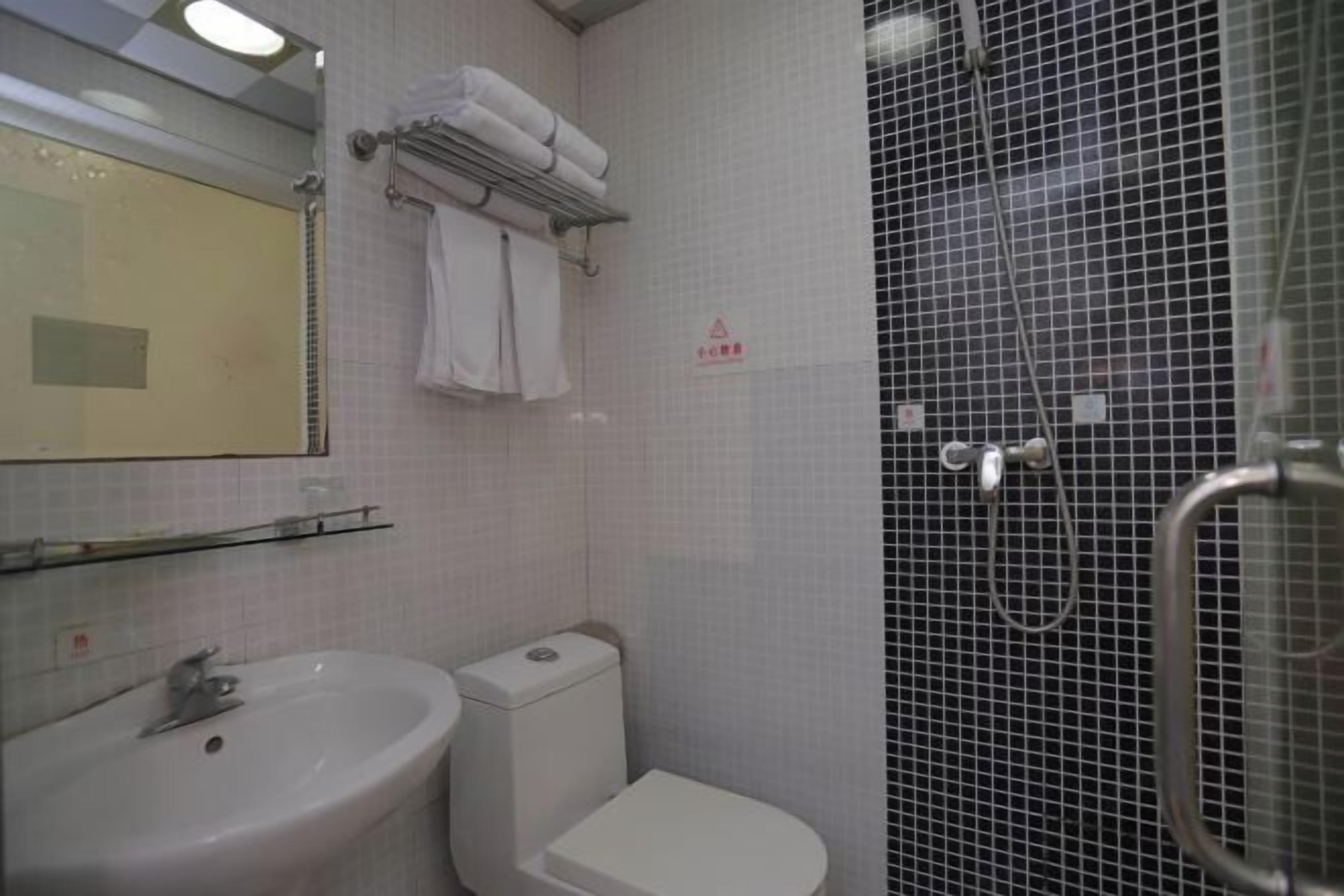 Ein Badezimmer mit Waschbecken, Toilette und Duschbereich.